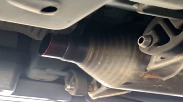severed partially cut catalytic converter under car